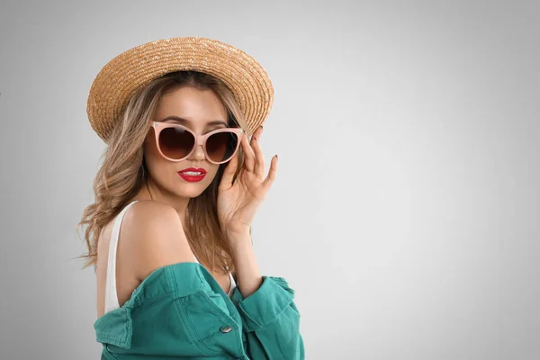 멋진 선글라스를 쓰고 밝은 회색 BAC 모자를 쓴 젊은 여자 — 스톡 사진