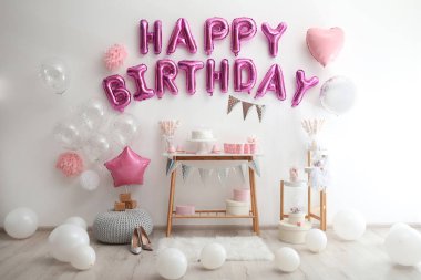 Dekorasyon odasındaki pembe balon mektuplarından oluşan mutlu yıllar.