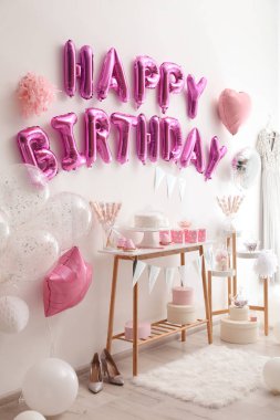 Dekorasyon odasındaki pembe balon mektuplarından oluşan mutlu yıllar.
