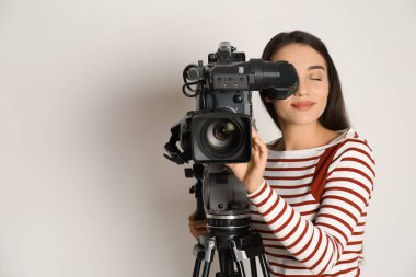 Beyaz arkaplanda profesyonel video kamerası olan operatör