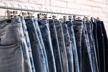 Tuğla duvarın yanında şık kotlu raflar, yakın plan.