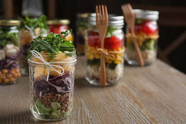 Glazen pot met gezonde maaltijd op houten tafel — Stockfoto