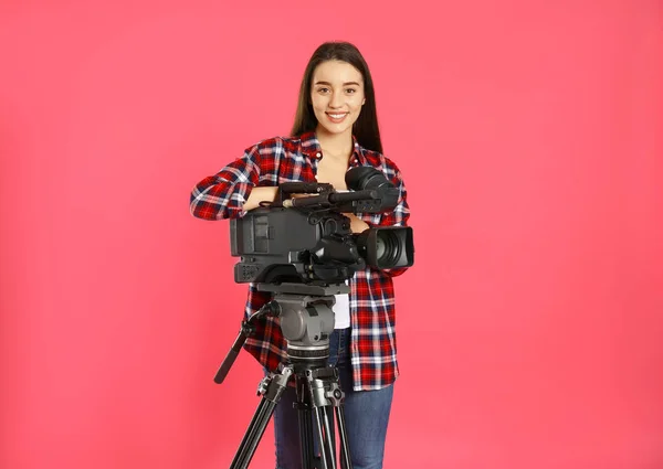 Operatör med professionell videokamera på rosa bakgrund — Stockfoto