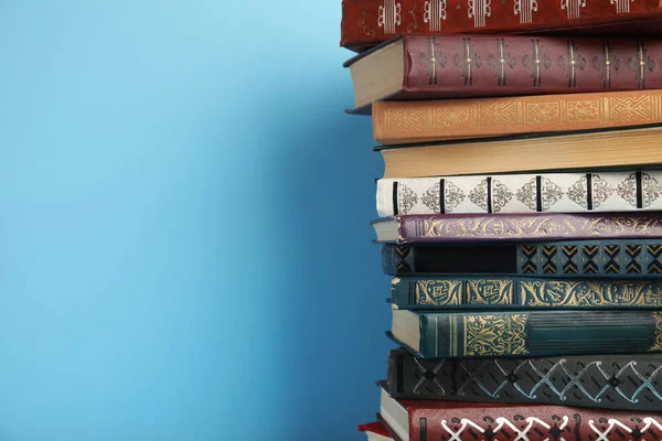 Pilha de livros de capa dura sobre fundo azul claro, espaço para tex — Fotografia de Stock