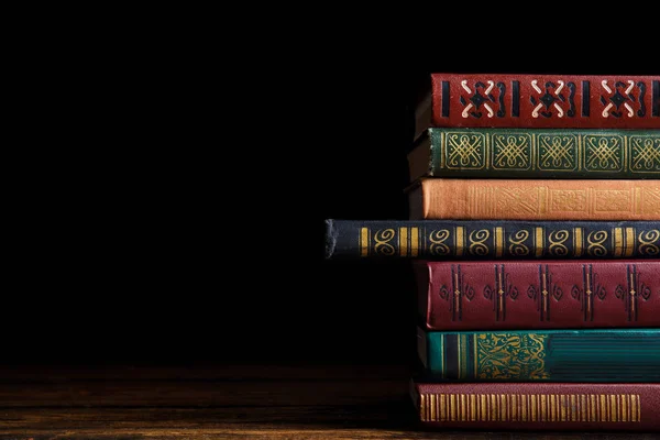 Συλλογή από διάφορα βιβλία σε ξύλινο τραπέζι κατά σκούρο backg — Φωτογραφία Αρχείου