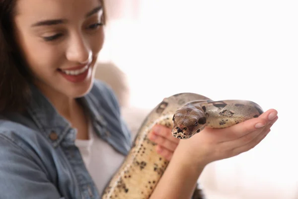 Mujer joven con su boa constrictor en casa, enfoque en la mano —  Fotos de Stock