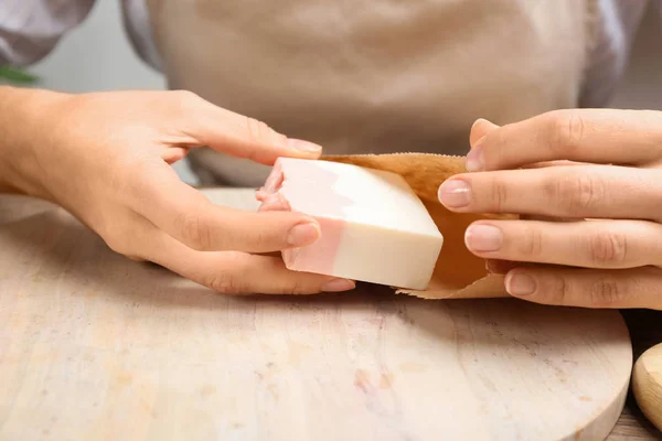 Mujer Poniendo Jabón Natural Hecho Mano Bolsa Papel Mesa Madera —  Fotos de Stock