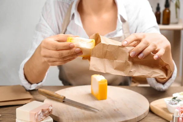 Mujer Poniendo Jabón Natural Hecho Mano Bolsa Papel Mesa Madera — Foto de Stock