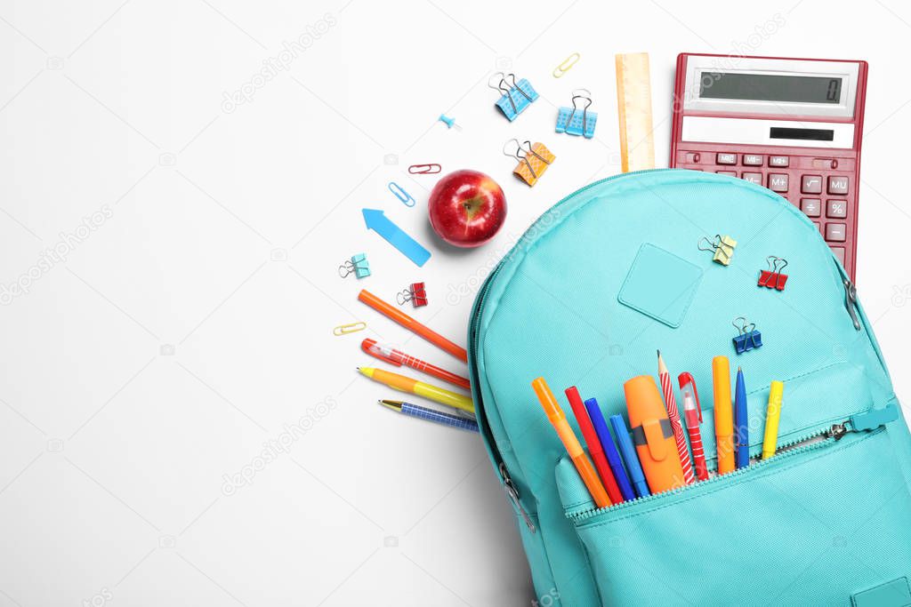 Stylish backpack with different school stationery on white background, top view