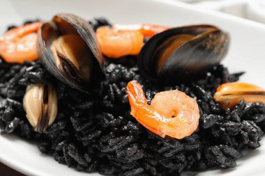 Lezzetli siyah risotto tabakta deniz ürünleri, yakın plan.