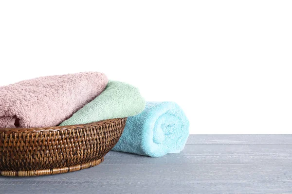 Fresh towels on grey wooden table against white background. Spac — Stock Photo, Image