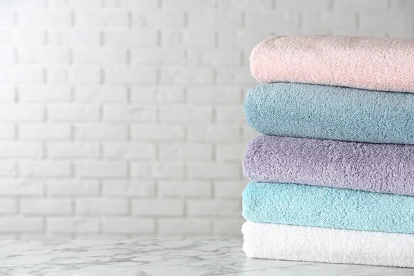 Stos czystych ręczników kąpielowych na białym marmurowym stole. Miejsce na tekst — Zdjęcie stockowe