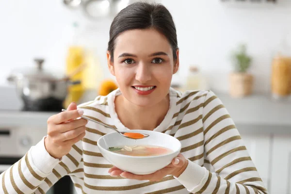 Young woman eating tasty vegetable soup indoors — Stock Photo, Image