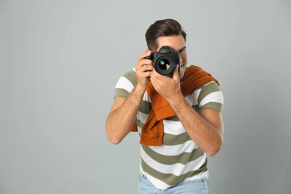 Profesionální fotograf pracující na světle šedém pozadí v st — Stock fotografie