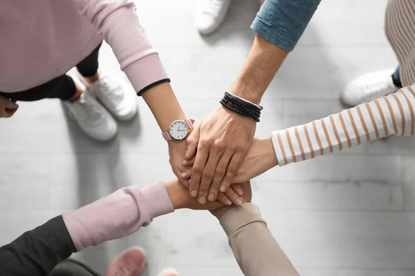 Menschen Die Sich Vor Hellem Holzhintergrund Die Hände Reichen Draufsicht — Stockfoto