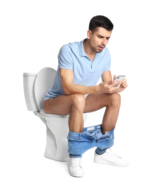 Homem Emocional Com Smartphone Sentado Vaso Sanitário Fundo Branco — Fotografia de Stock