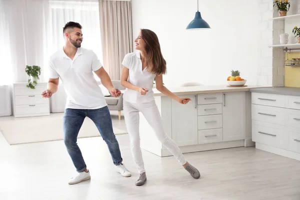 Adorável jovem casal dançando na cozinha em casa — Fotografia de Stock