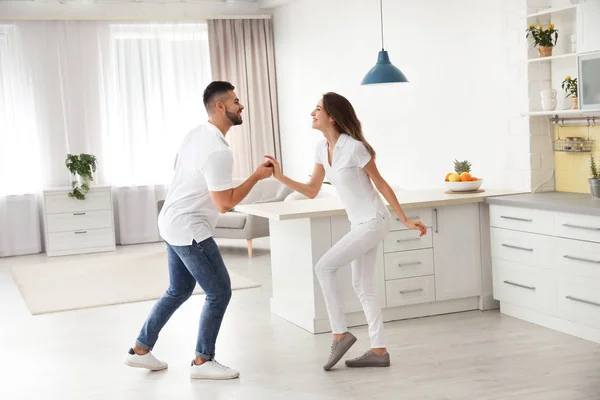 Adorável jovem casal dançando na cozinha em casa — Fotografia de Stock