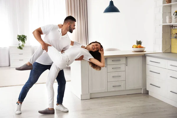 Adorável jovem casal dançando na cozinha em casa — Fotografia de Stock