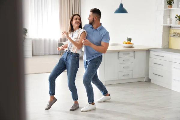 Härligt ungt par dansar i köket hemma — Stockfoto