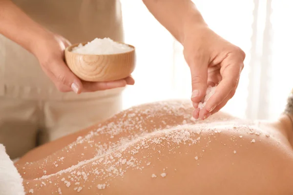 Jovem mulher tendo procedimento de limpeza corporal com sal marinho no spa — Fotografia de Stock