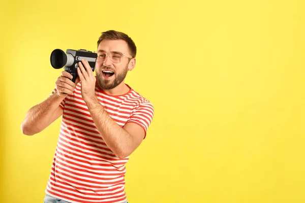 若いです男とともにヴィンテージビデオカメラ上の黄色の背景 テキストのためのスペース — ストック写真