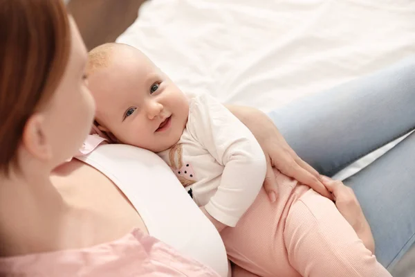 Junge Frau mit ihrem kleinen Baby, das sich nach dem Stillen ausruht — Stockfoto