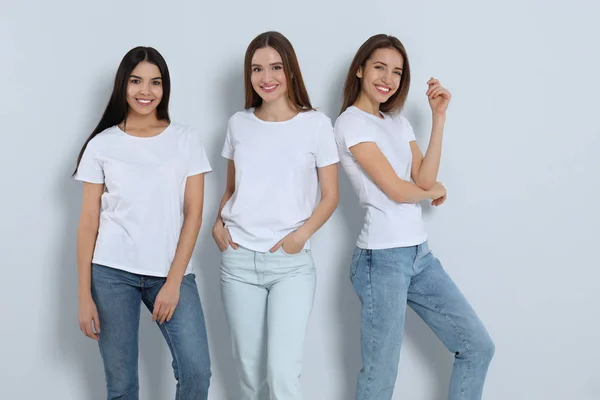 Grupo de mulheres jovens em jeans elegantes no fundo claro — Fotografia de Stock