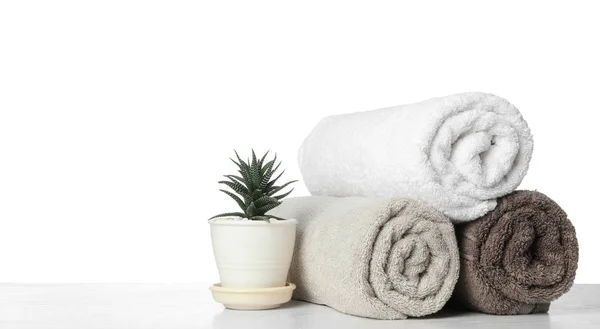 Прокат чистые полотенца для ванной комнаты и комод на столе против — стоковое фото