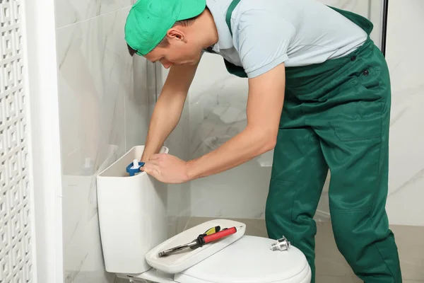Profesionální instalatér opravy WC tank v koupelně — Stock fotografie