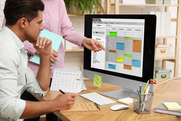 Colegas que trabajan con la aplicación de calendario en el ordenador en la oficina — Foto de Stock