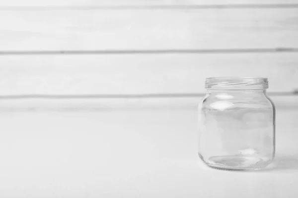 Frasco de vidro vazio na mesa branca, espaço para texto — Fotografia de Stock
