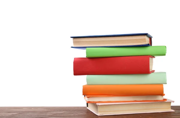 Montón de libros coloridos sobre mesa de madera sobre fondo blanco — Foto de Stock