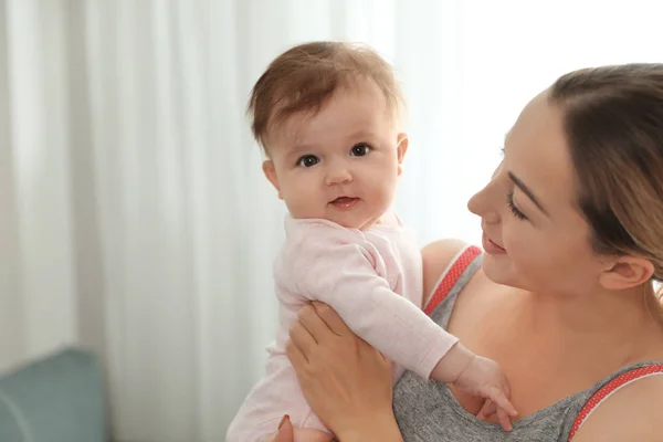 Jovem com seu bebê bonito em casa — Fotografia de Stock