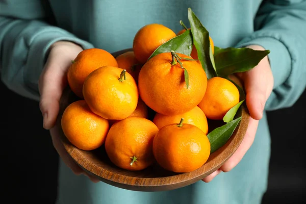 Woman holding bowl of tangerines, closeup. Juicy citrus fruit — Stock Photo, Image