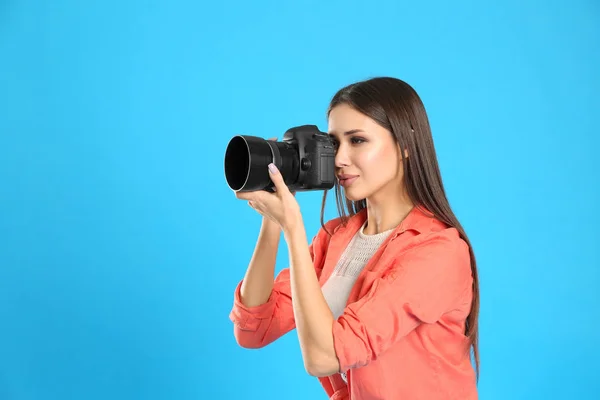 Profesionální fotograf pracující na světle modrém pozadí v st — Stock fotografie