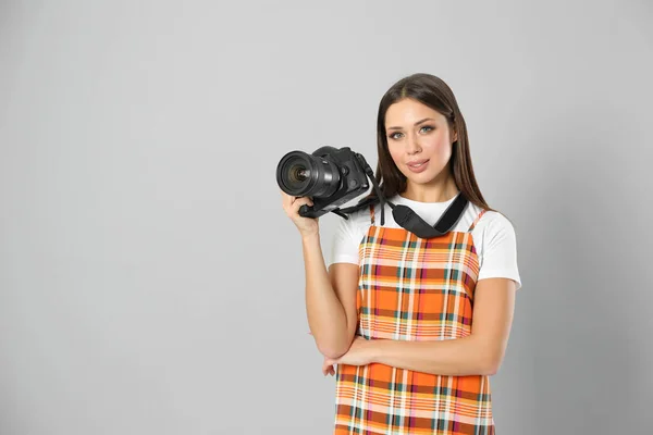 Profesionální fotograf pracující na světle šedém pozadí v st — Stock fotografie