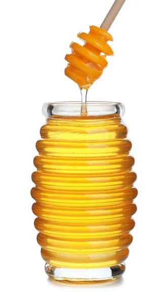 Honig tropft aus einem Löffel in ein Glas, isoliert auf weiß — Stockfoto