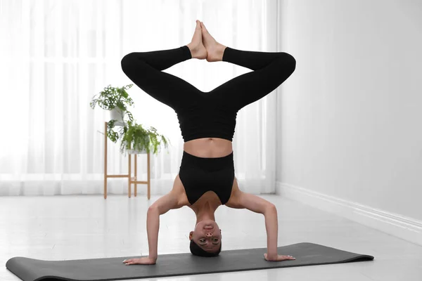 Profesionální mladý akrobat cvičit jógu doma — Stock fotografie