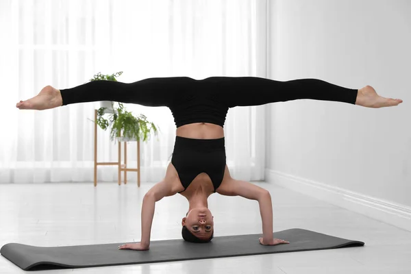 Professional young acrobat practicing yoga at home — Stock Photo, Image