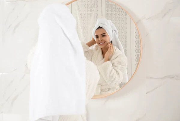 鏡の近くのタオルに包まれた髪の若い女性室内 — ストック写真