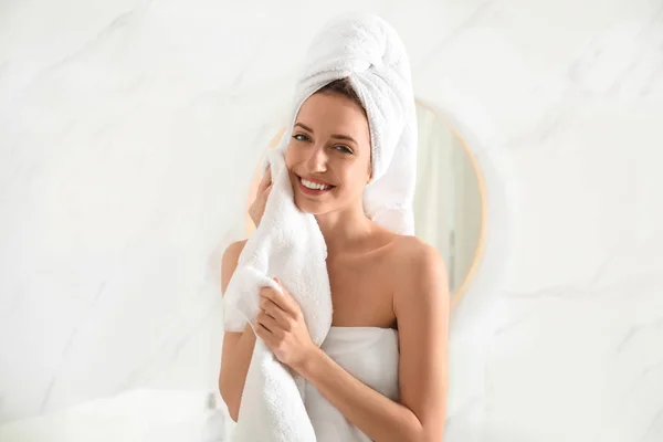 Young woman wiping face with towel in bathroom — Stock Photo, Image