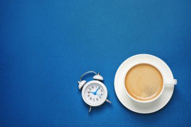 Mavi arka planda klasik siyah kahve ve alarm saati. Üstü açık, yazı için yeri var. 2020 Yılı Rengi