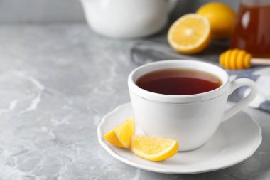 Açık gri mermer masada ballı ve limonlu taze çay, yakın plan.