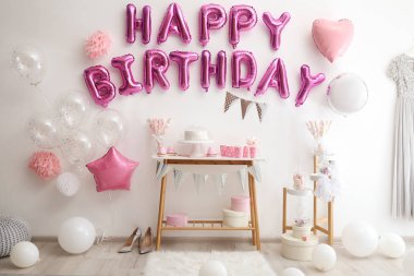 Dekorasyon odasındaki pembe balon mektuplarından oluşan mutlu yıllar.