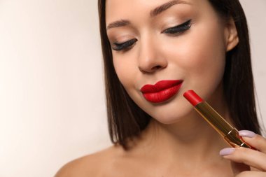 Açık arkaplanda kırmızı ruj olan güzel bir kadın. Metin için boşluk