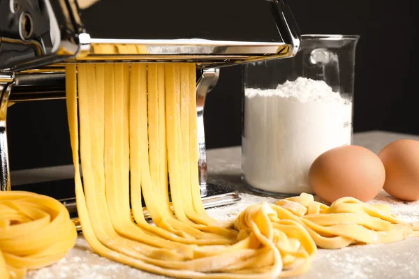 Машина для виготовлення макаронних виробів з тістом та продуктами на сірому столі, закрити — стокове фото