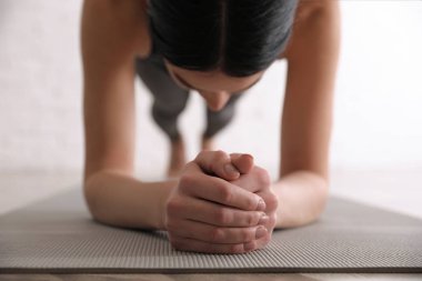 Yoga stüdyosunda ön kol tahtası çalışması yapan genç bir kadın, kapat.
