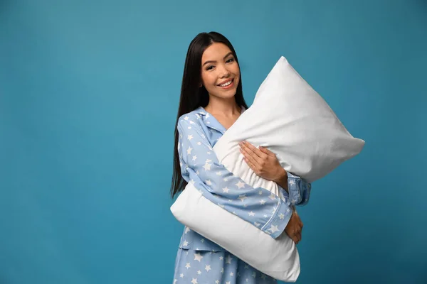 Krásná asijská žena s polštářem na modrém pozadí. Čas jít spát — Stock fotografie