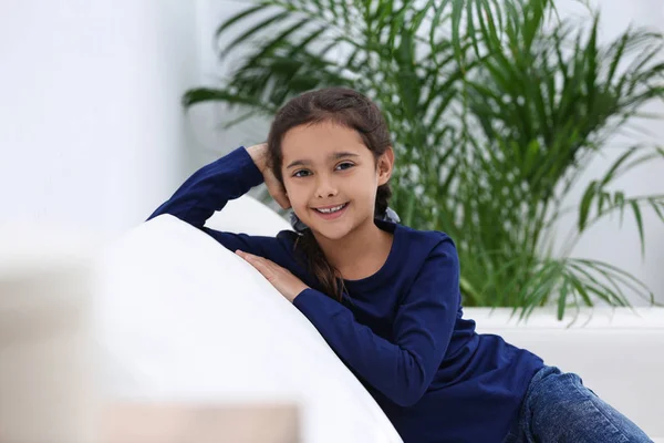 लिव्हिंग रूम मध्ये सोफा वर सुंदर लहान मुलगी — स्टॉक फोटो, इमेज